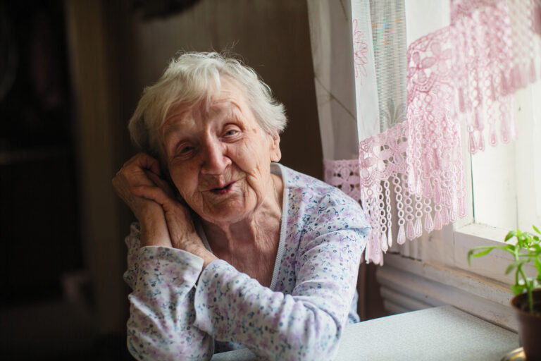 An,Elderly,Woman,Sitting,At,The,Table